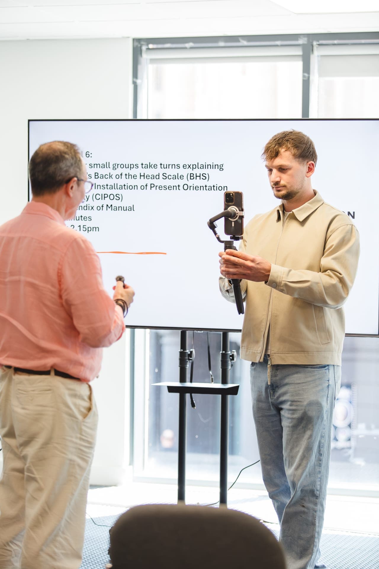 Adam Watters filming on a gimbal-stabilised phone at an EMDR training day