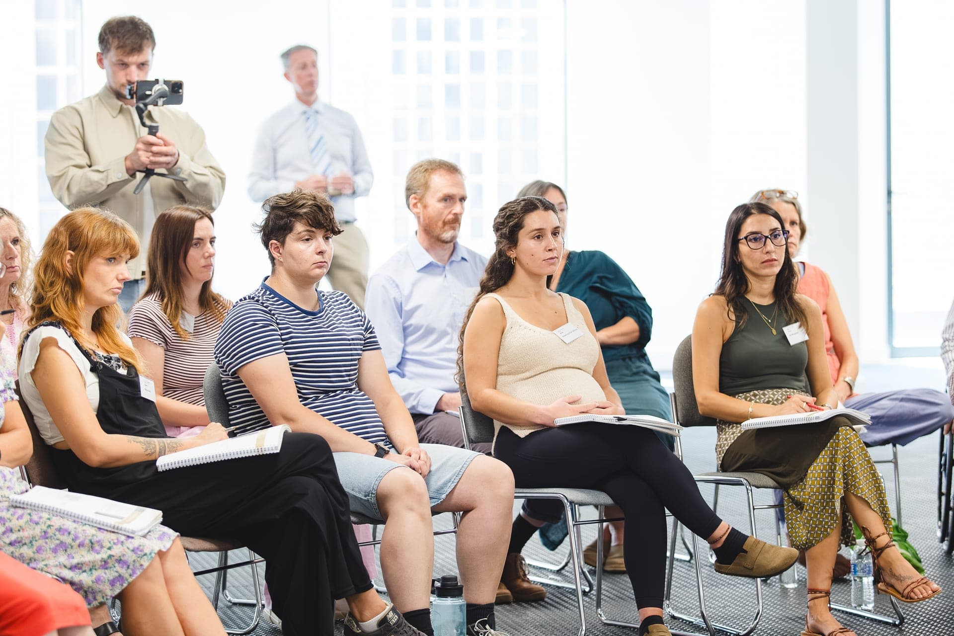Delegates seated with notebooks during an accredited EMDR training day, being filmed from the back of the room
